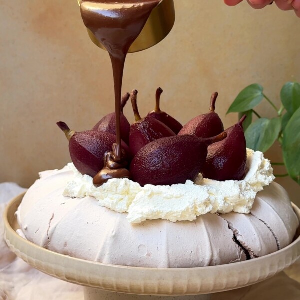 Pouring chocolate sauce over Christmas Pavlova