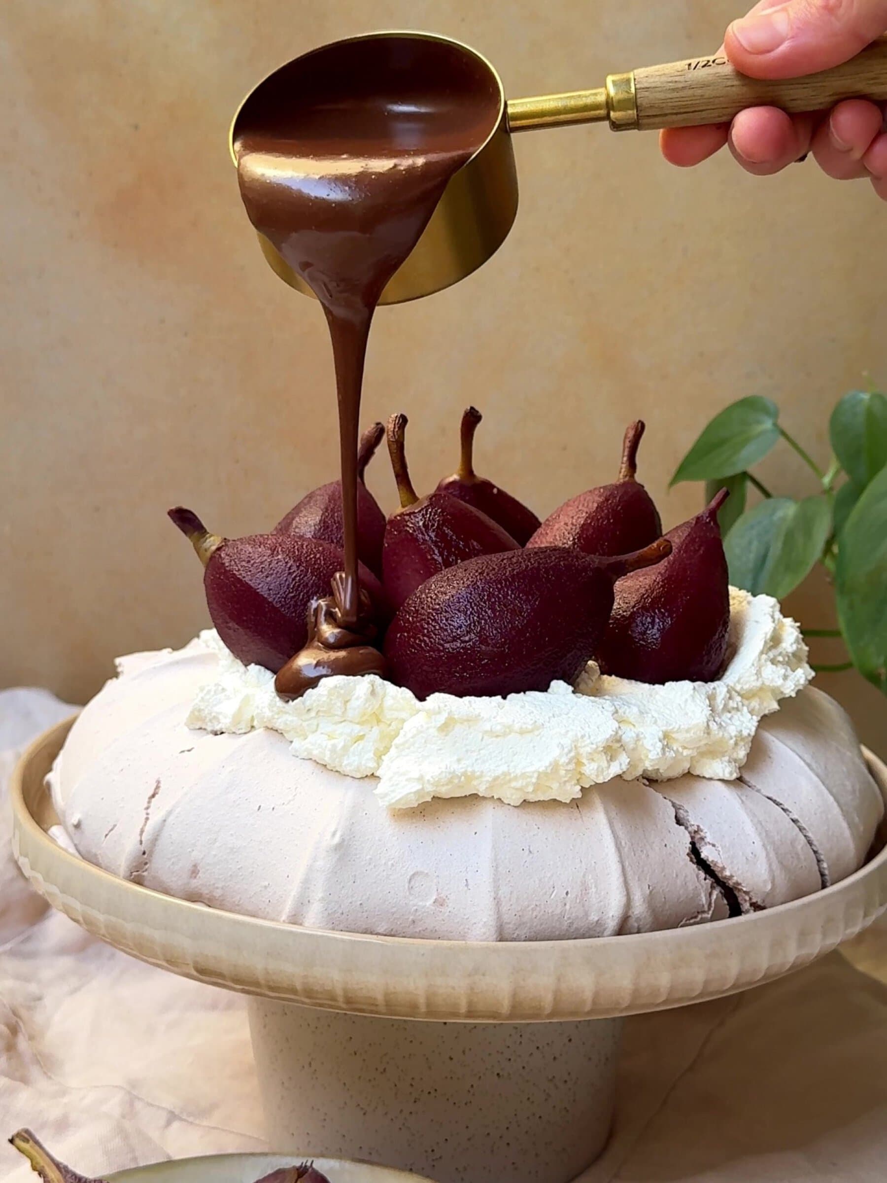 Pouring chocolate sauce over Christmas Pavlova.