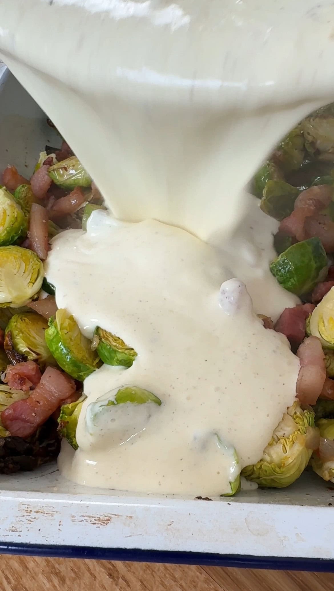 adding cream to the brussels sprouts casserole.