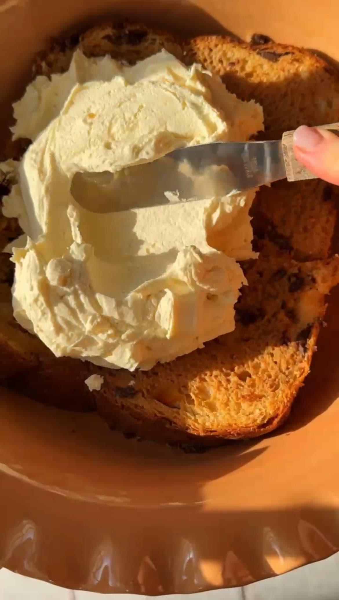 spreading mascarpone on the panettone.