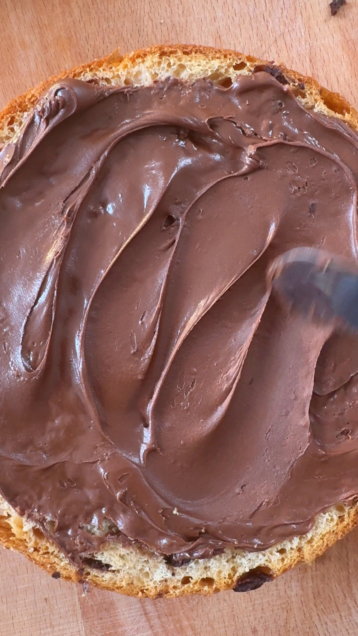 spreading nutella on a layer of tiramisu cake.