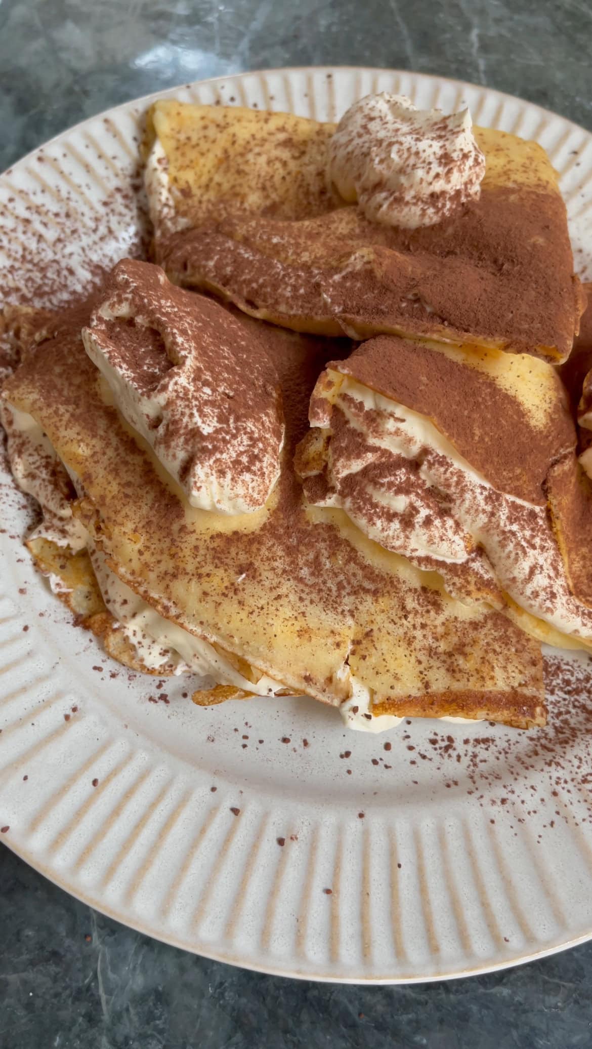 dusting pancakes with cocoa powder.