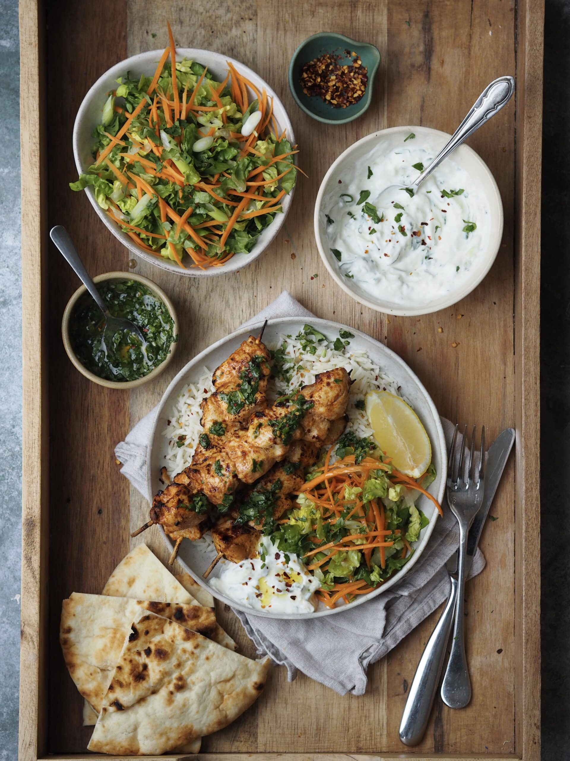 baked chicken skewers with crunchy salad and rice.