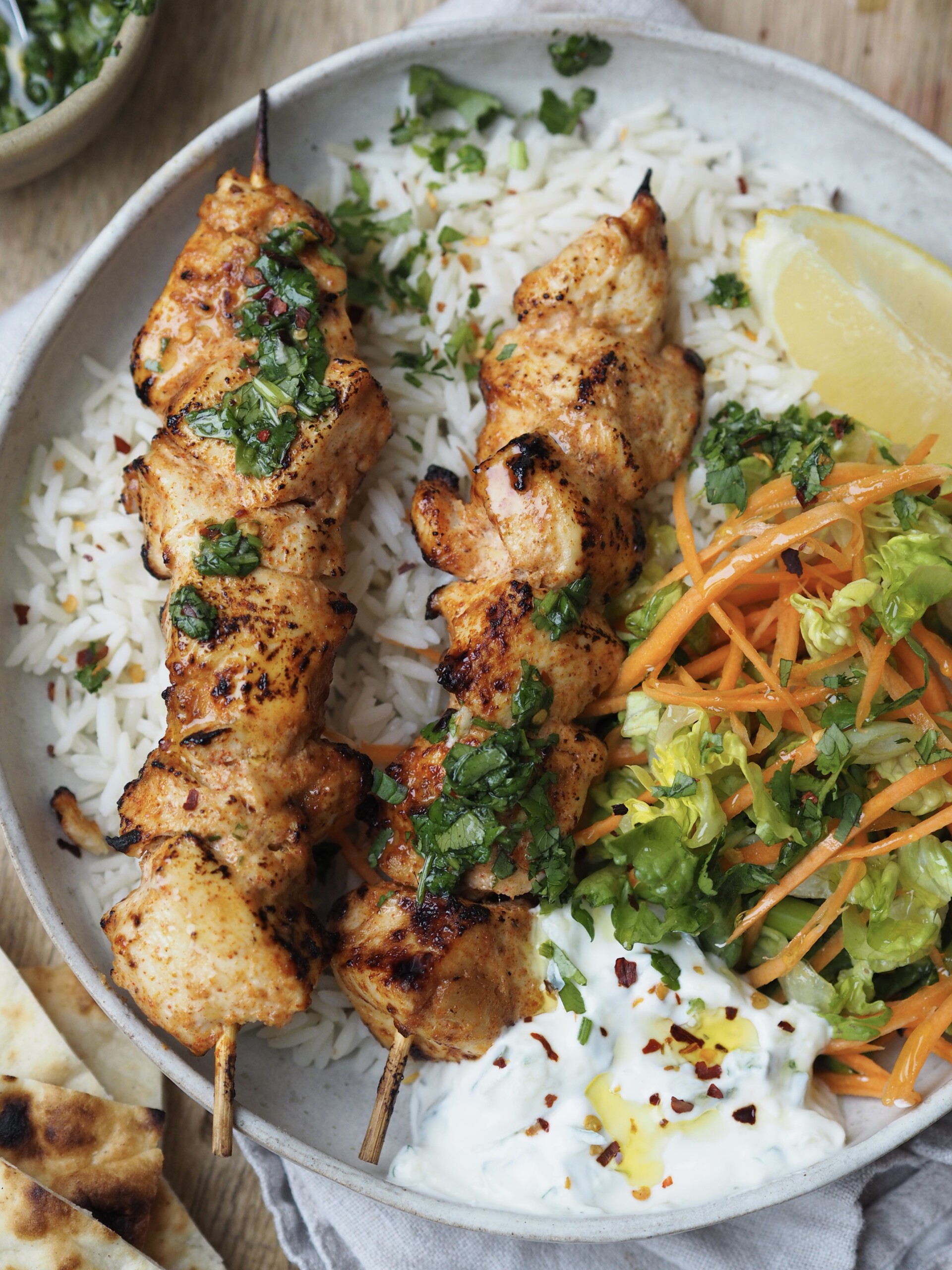 baked chicken skewers with crunchy salad and rice.