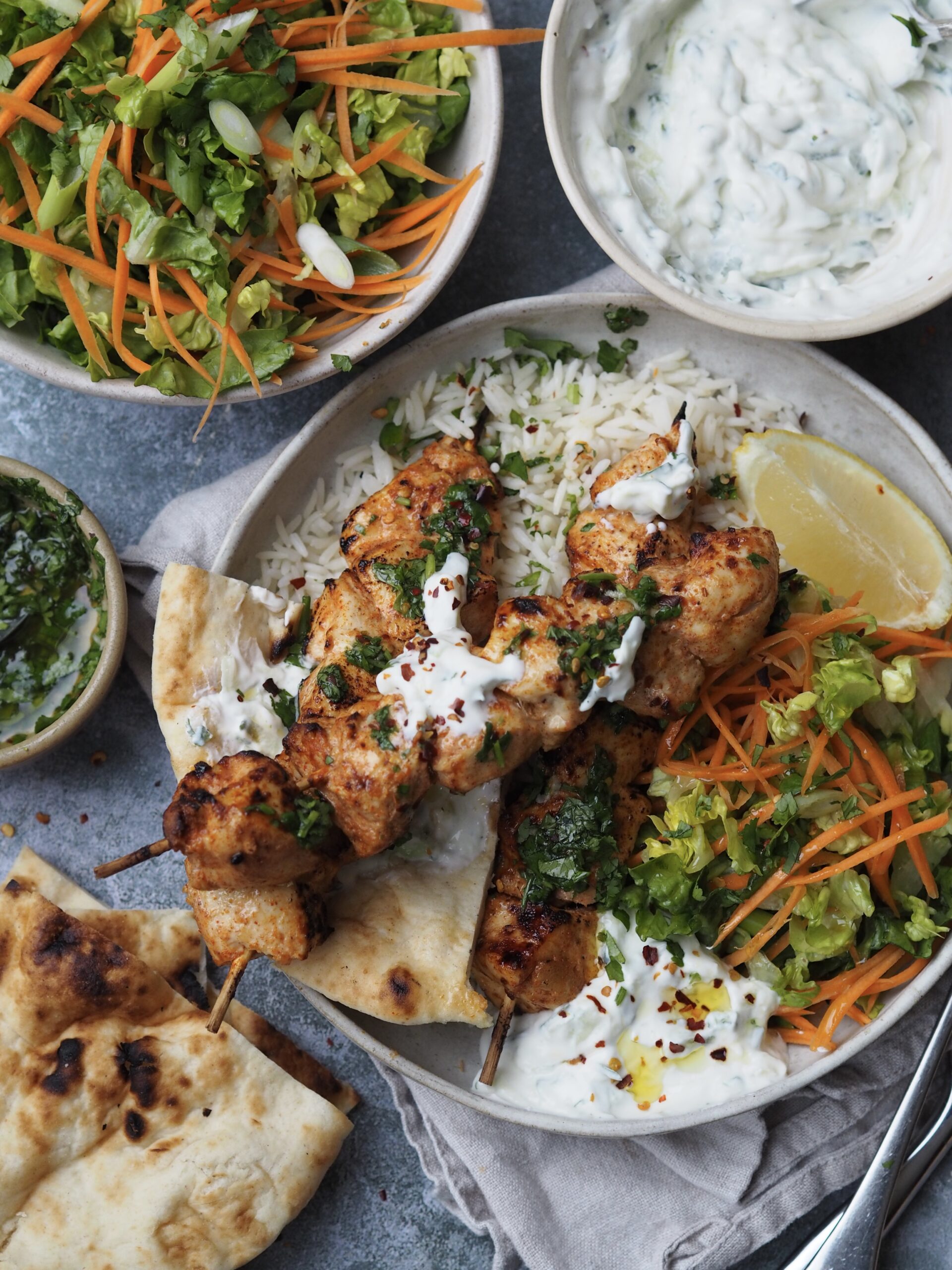 baked chicken skewers with crunchy salad and rice.