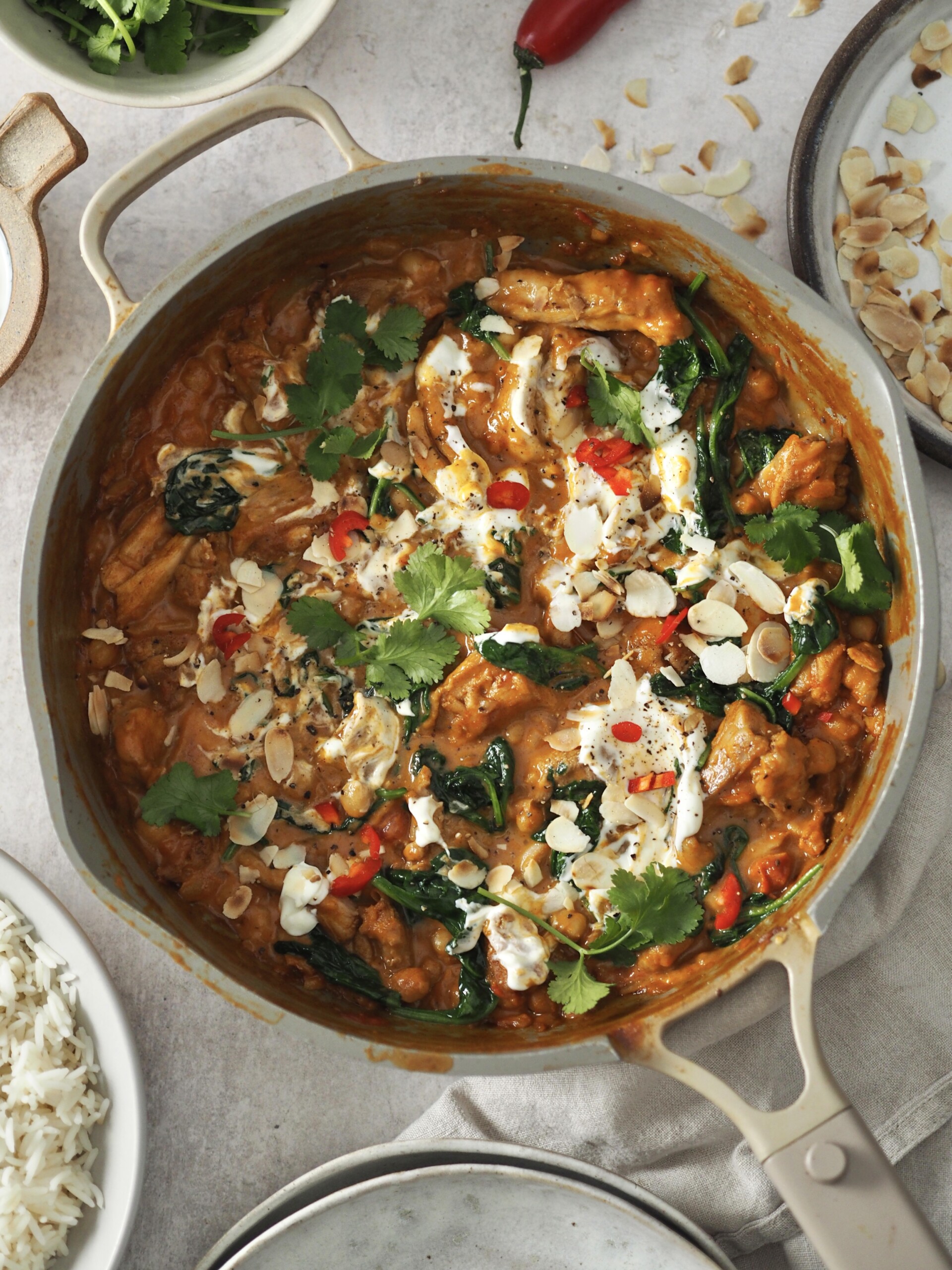 chicken and chickpea curry garnished with yoghurt and herbs.