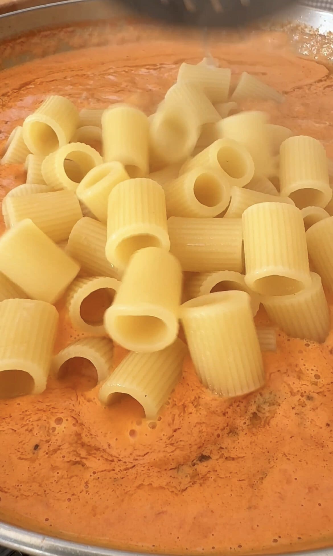 stirring in pasta to the chicken and vodka sauce.