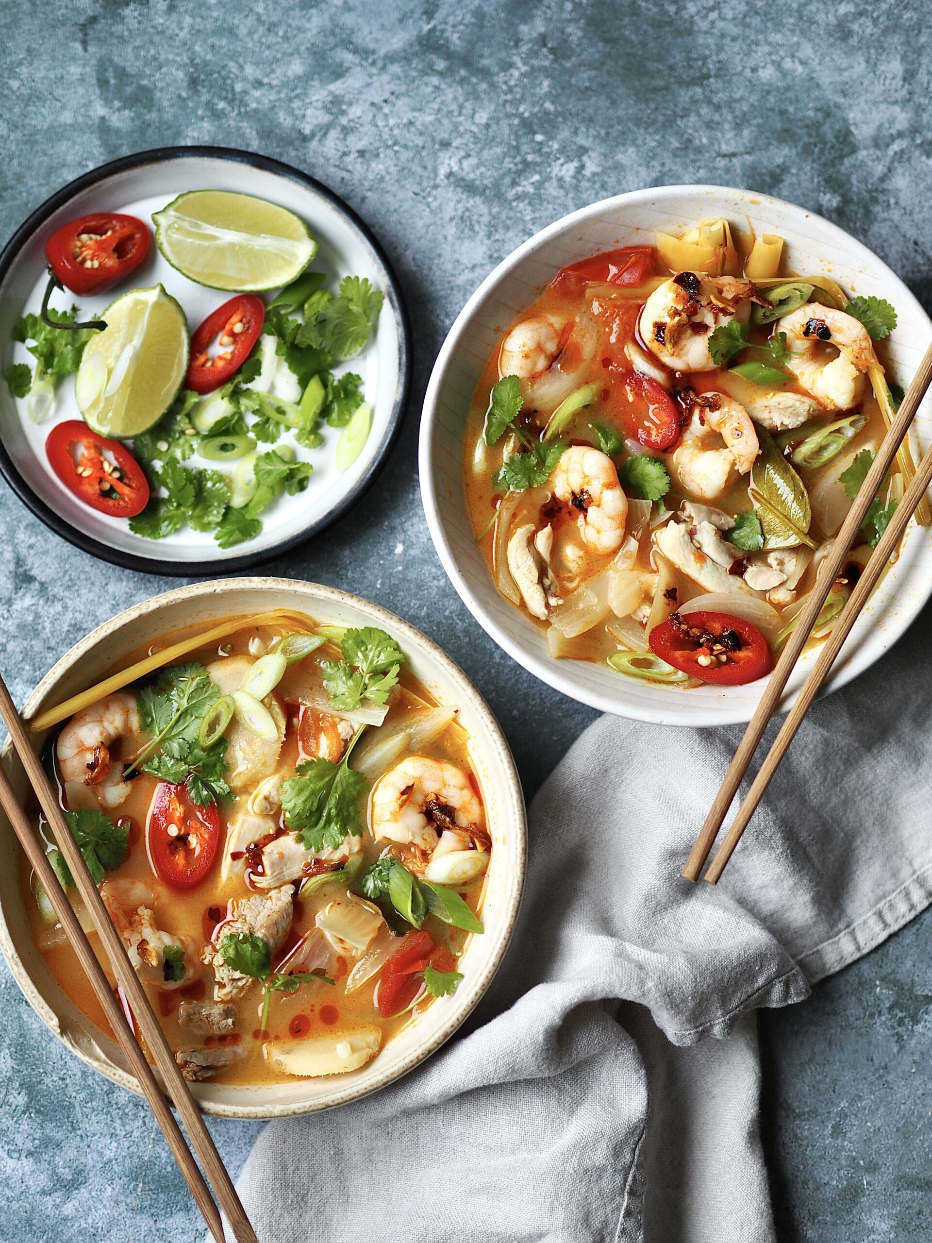 chicken tom yum soup in a white bowl with chilli and coriander on top.