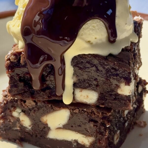 chocolate and white chocolate brownies stacked with ice cream on top.