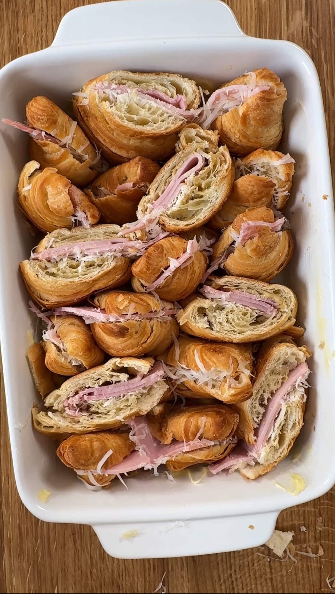 adding croissants to the dish.