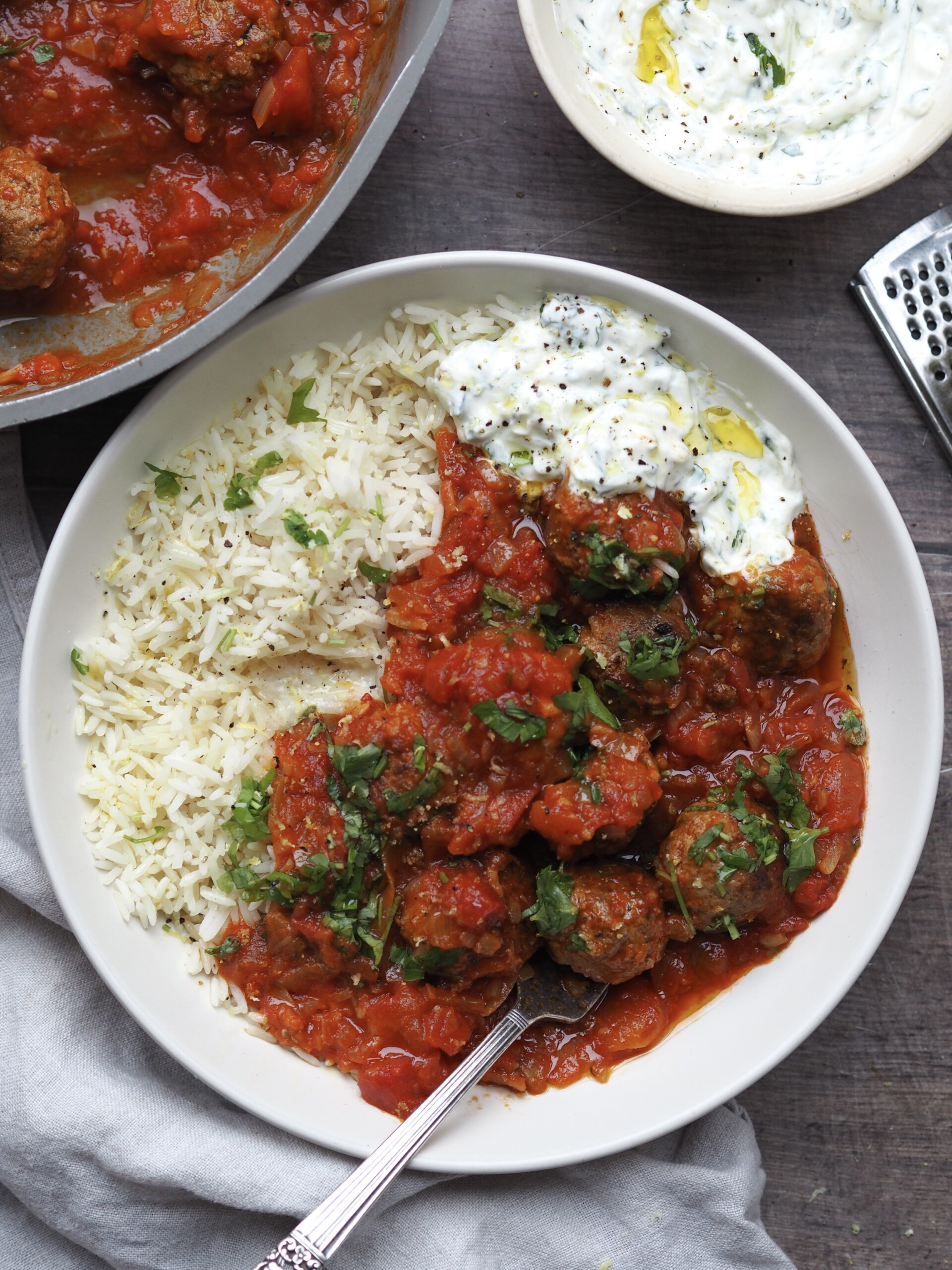 lamb mince meatballs plated with rice and tzatziki.