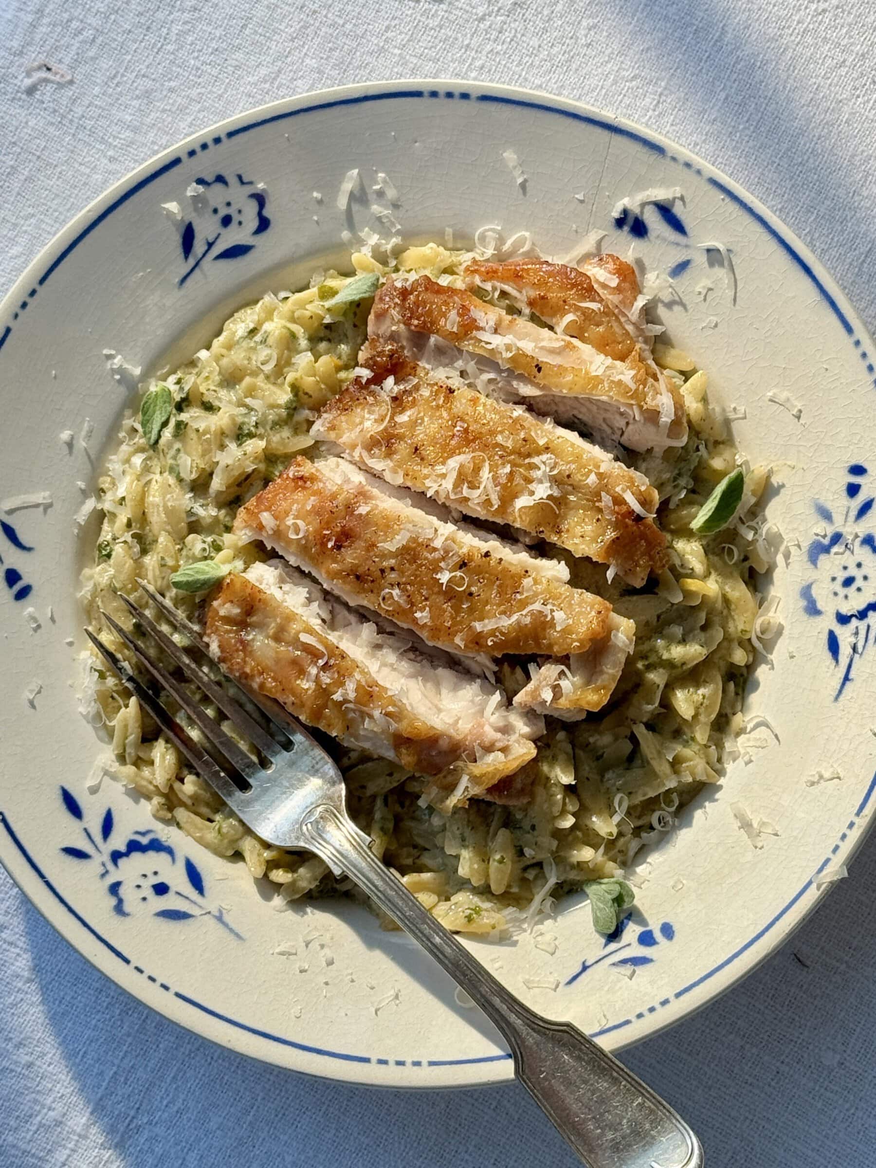 lemon chicken orzo in a bowl with blue flowers.