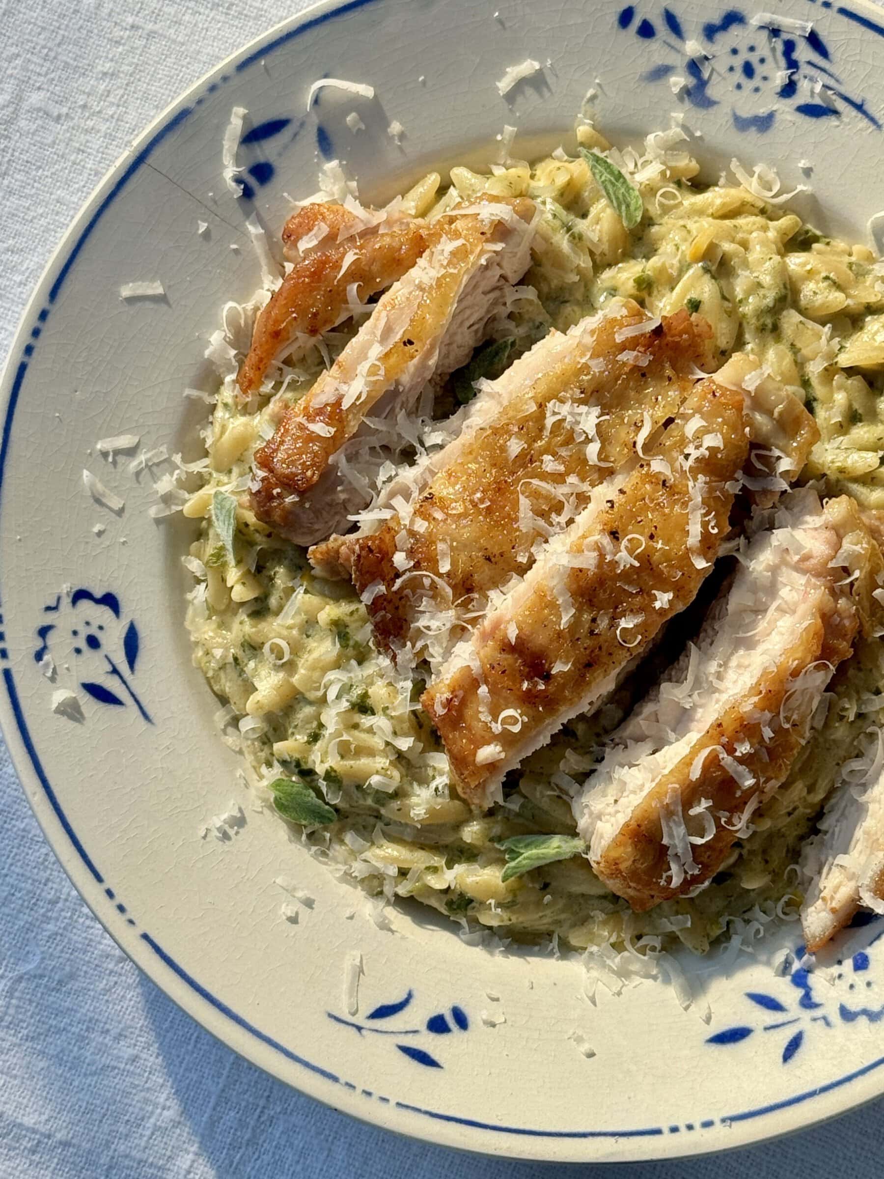 lemon chicken orzo in a bowl with blue flowers.