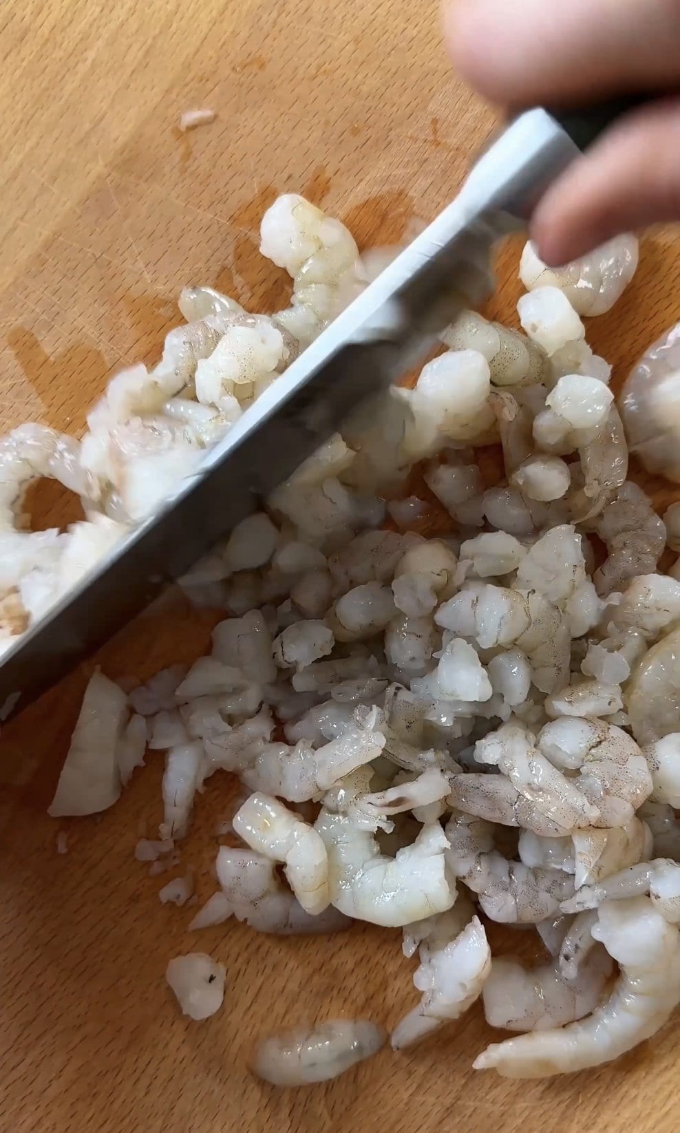 chopping prawns on the board for the mixture.