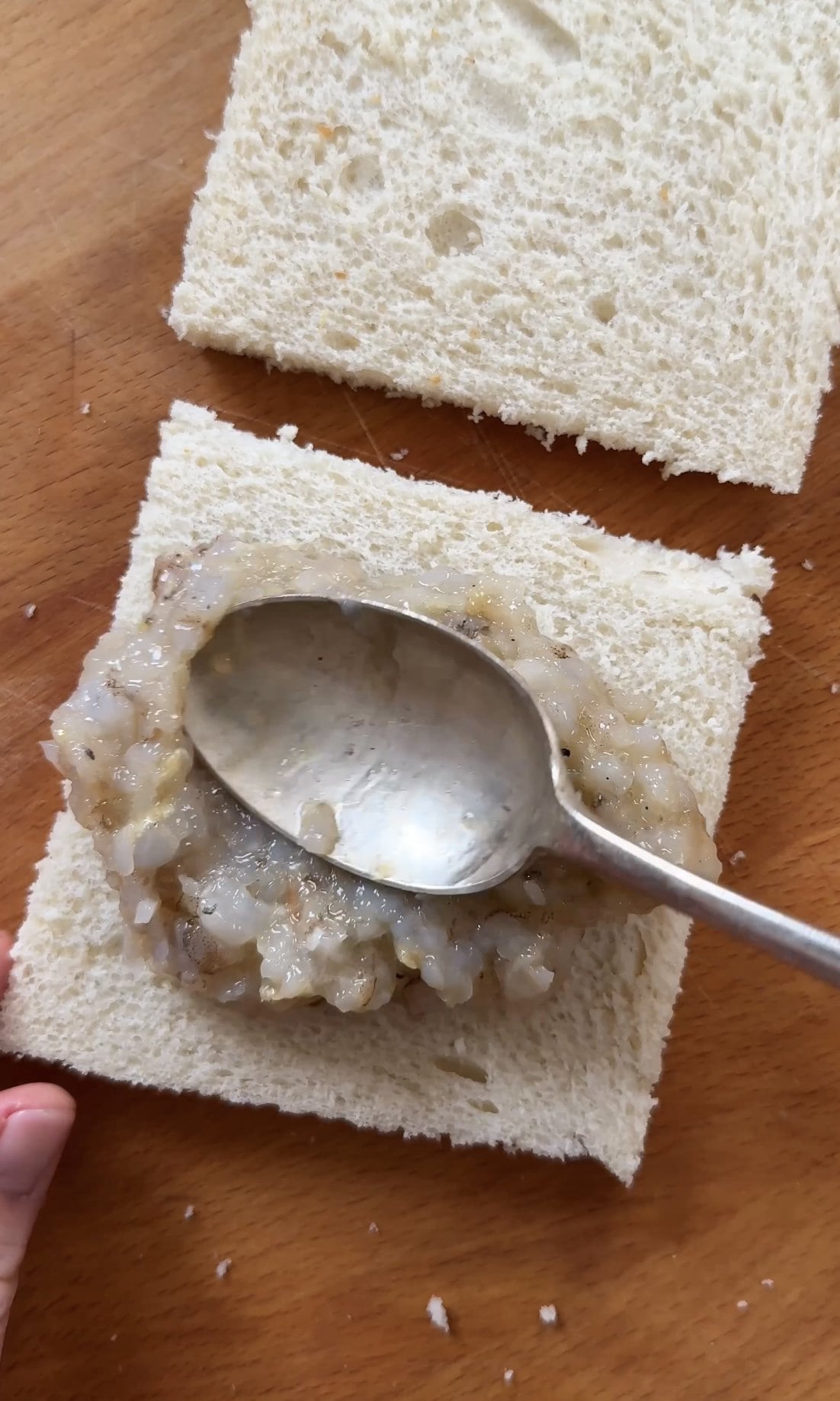 adding prawn mixture to sandwiches.