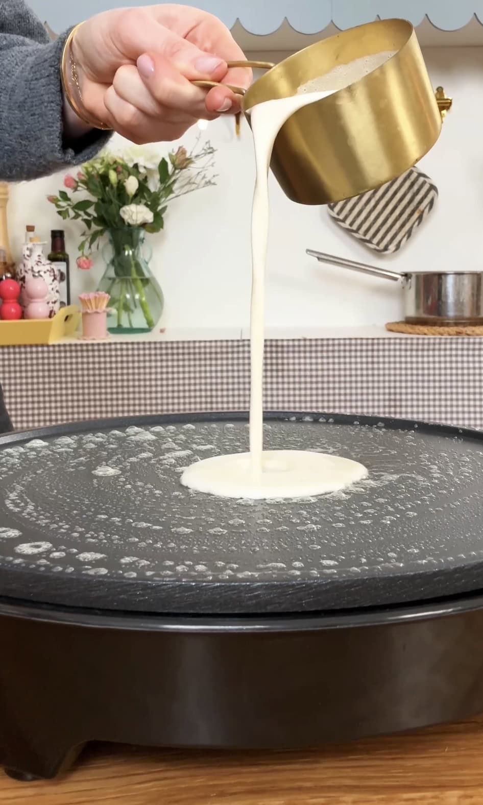 pouring crepe batter on pan.