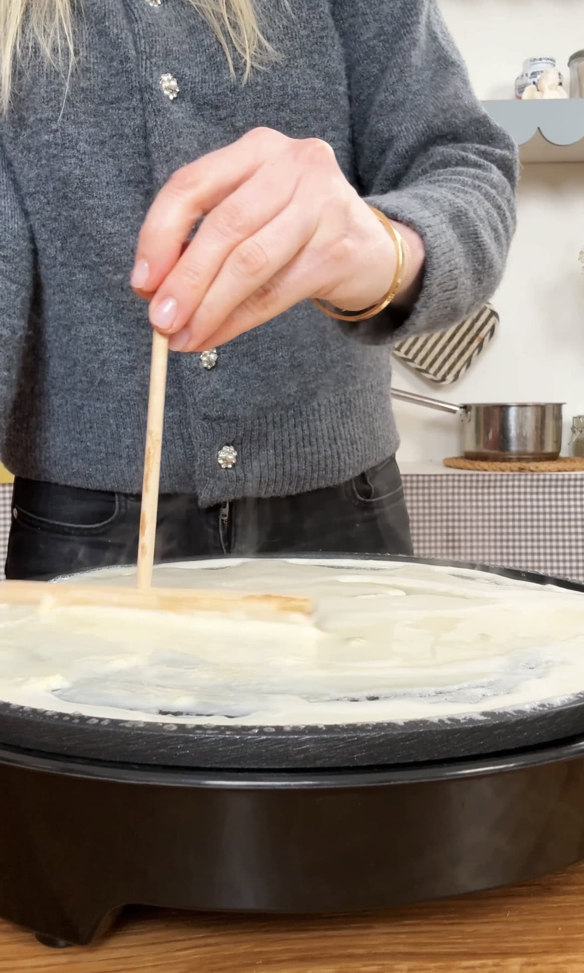 smoothing crepe batter on crepe pan.