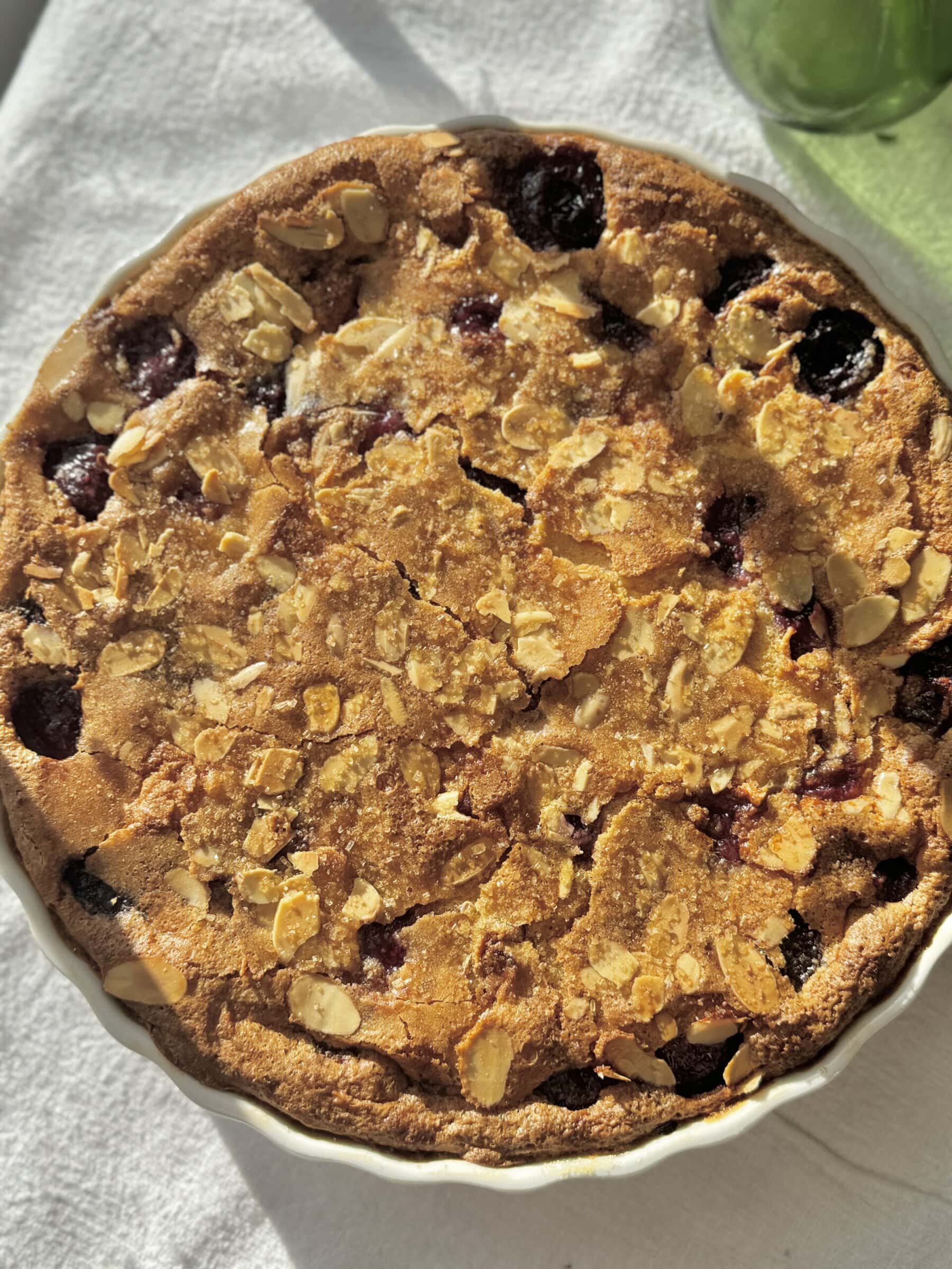 clafoutis aux cerises baked in a white pie dish.