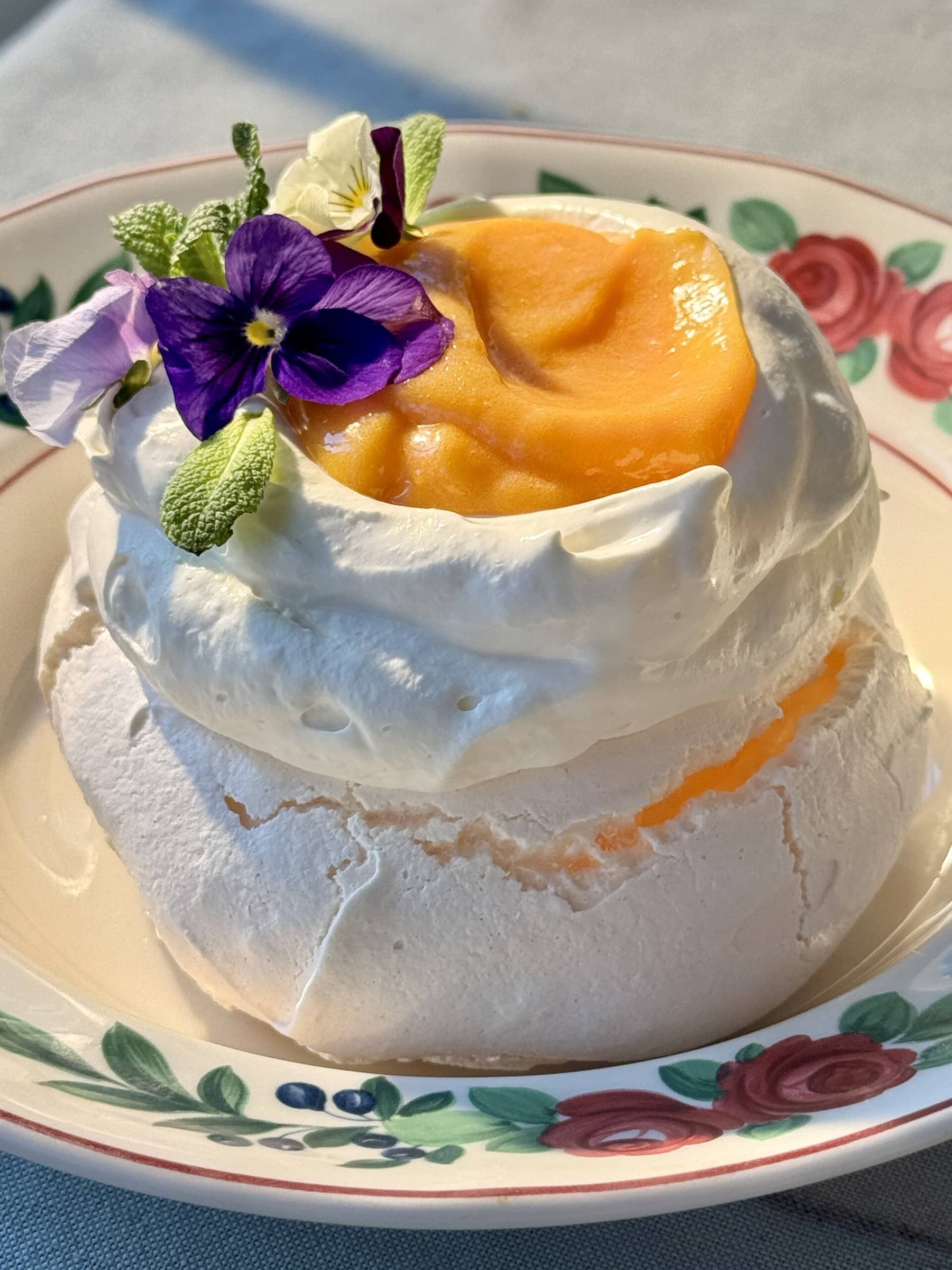 one lemon meringue on a plate topped with whipped cream and lemon curd.