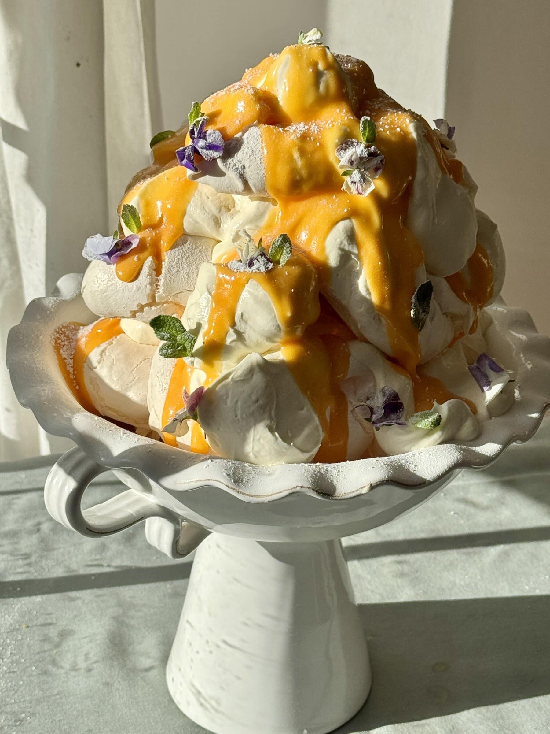 lemon meringues tower with lemon curd and edible flowers.