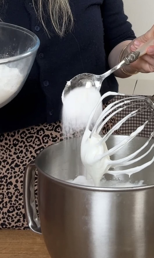 adding sugar one spoon at a time to lemon merigues.