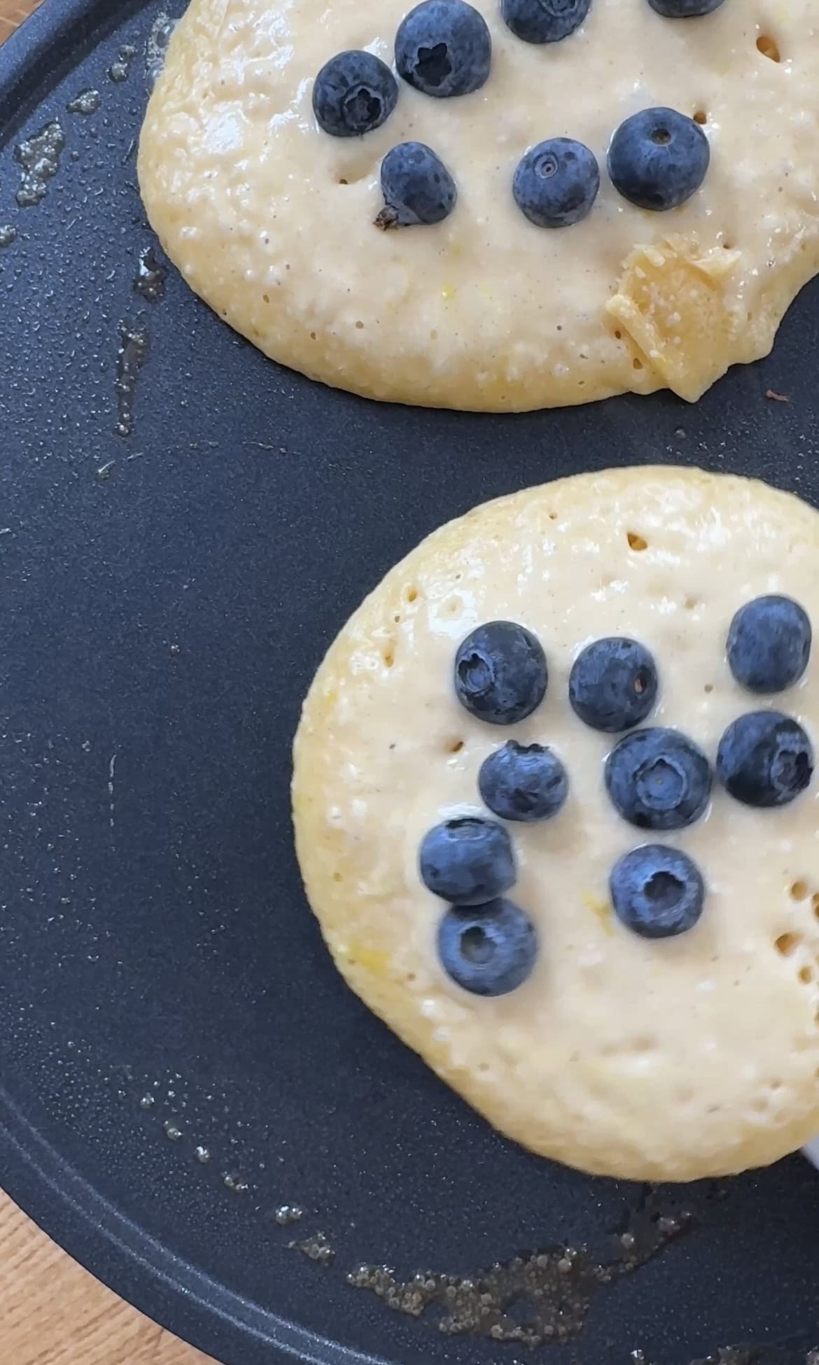 topping with blueberries when frying lemon ricotta blueberry pancakes.