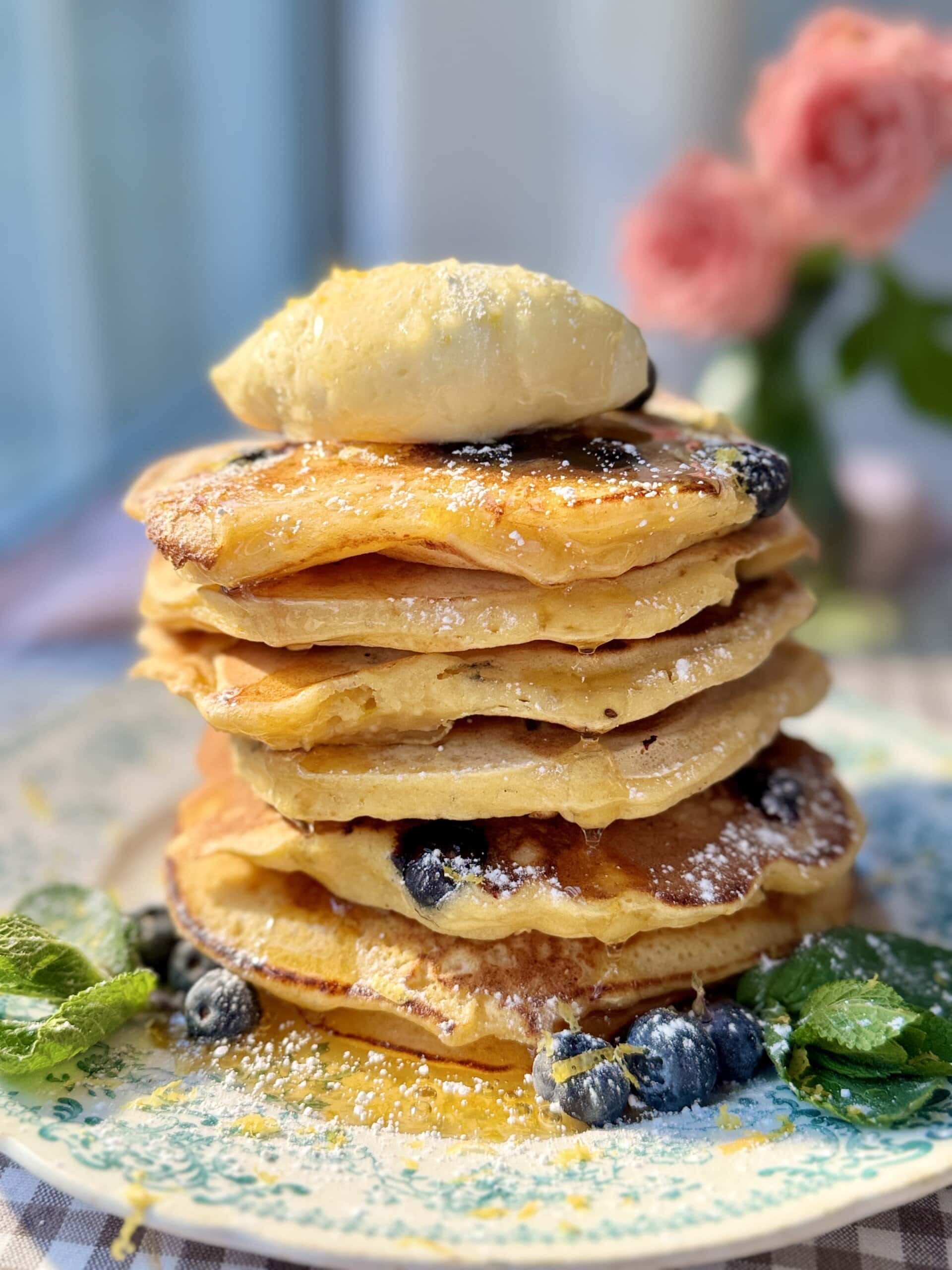 a stack of lemon ricotta blueberry pancakes with whipped honey butter.