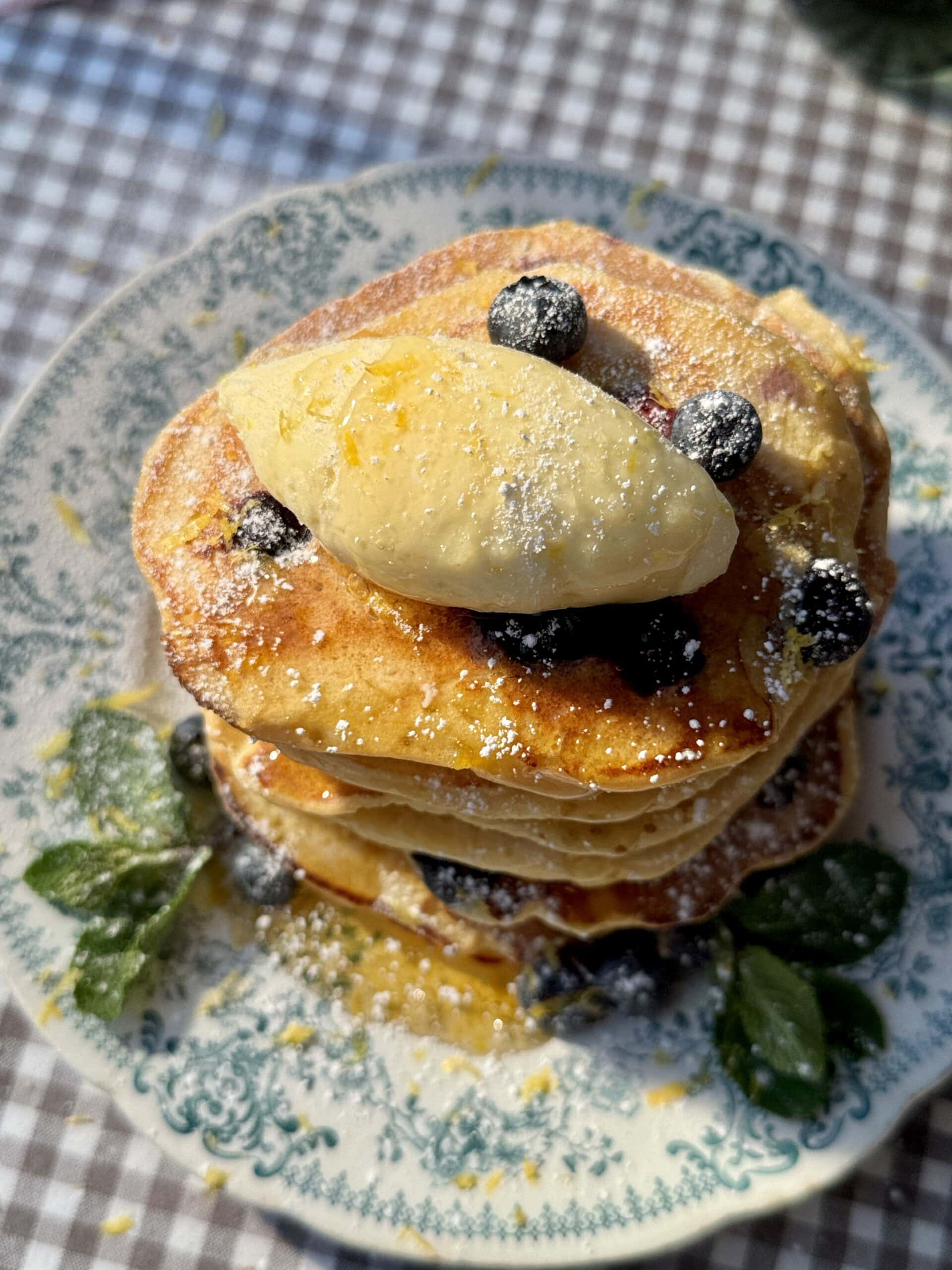 a stack of lemon ricotta blueberry pancakes with whipped honey butter.