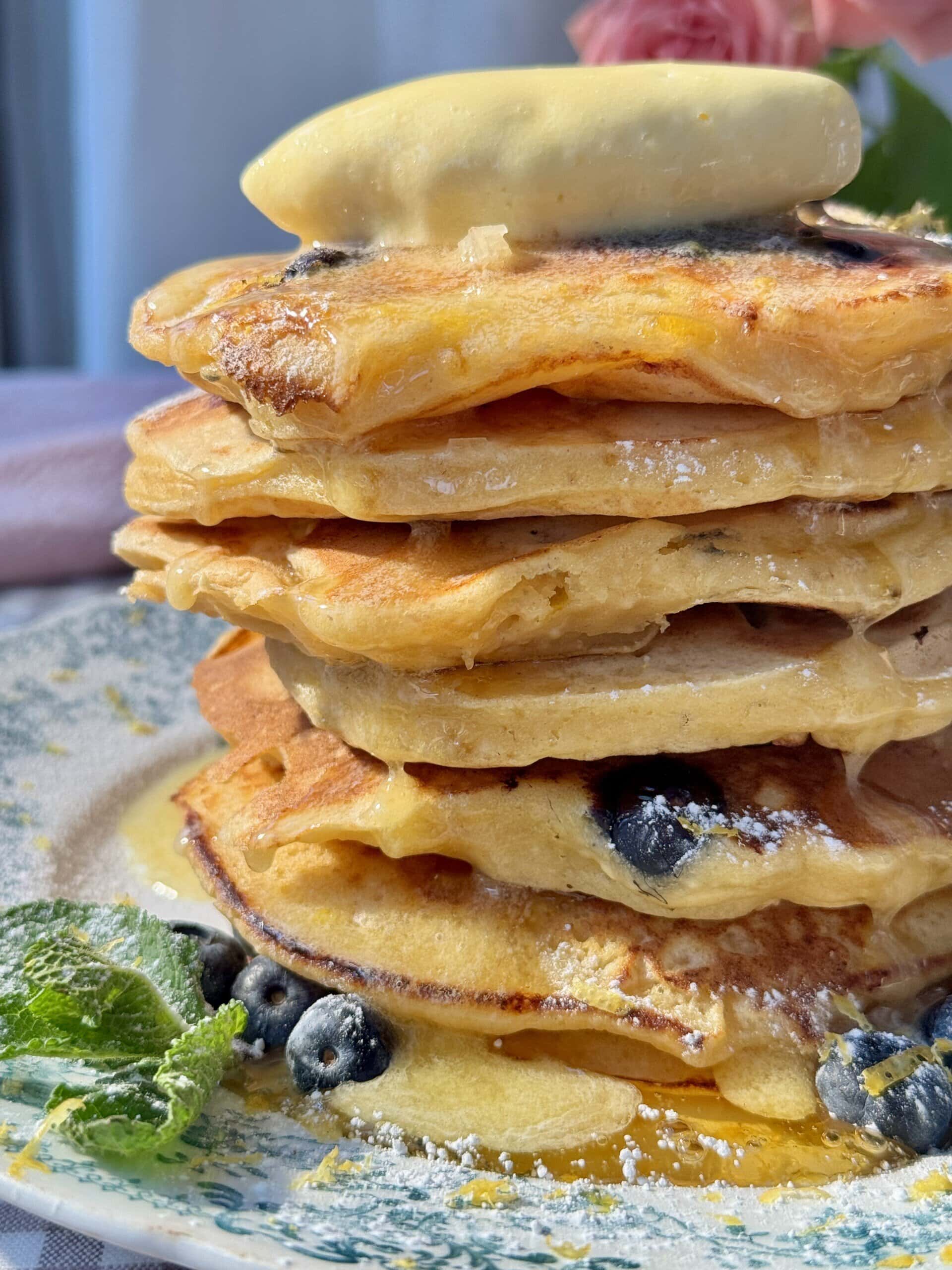 a stack of lemon ricotta blueberry pancakes with whipped honey butter.