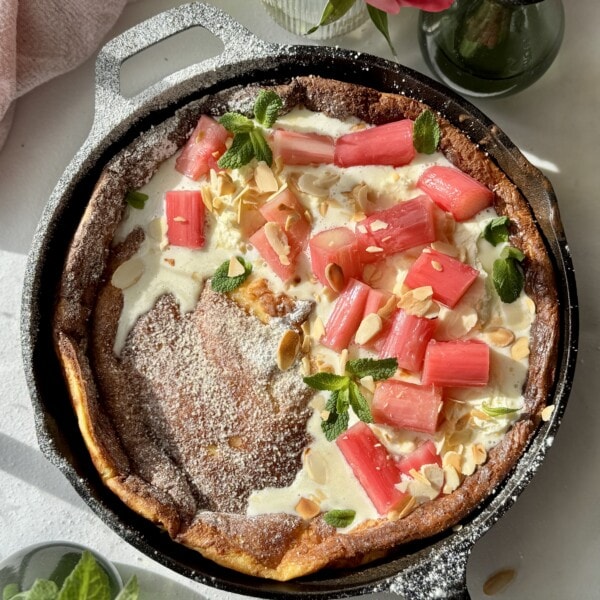 pannukakku in a cast iron pan with whipped mascarpone cream and poached rhubarb.