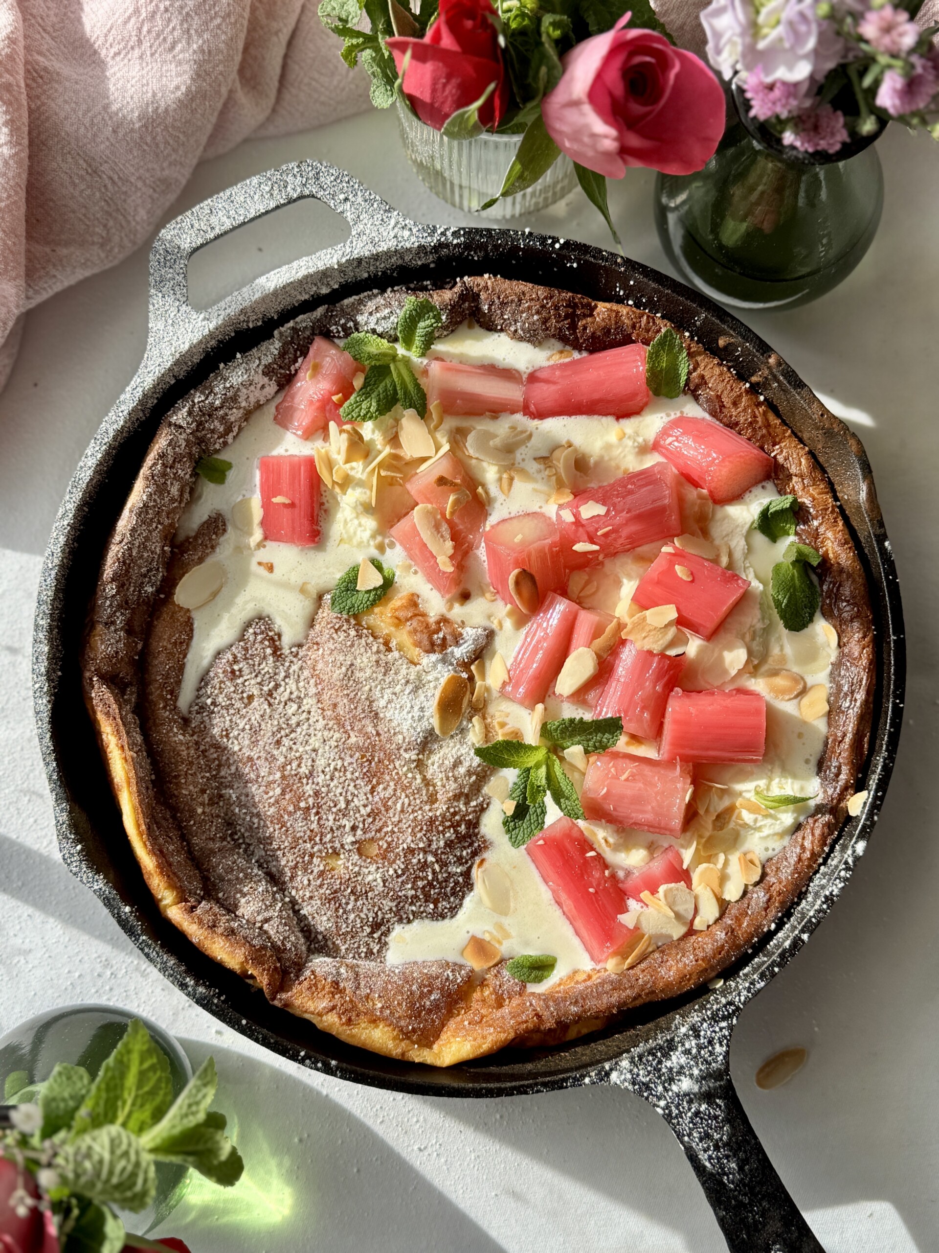 pannukakku in a cast iron pan with whipped mascarpone cream and poached rhubarb.