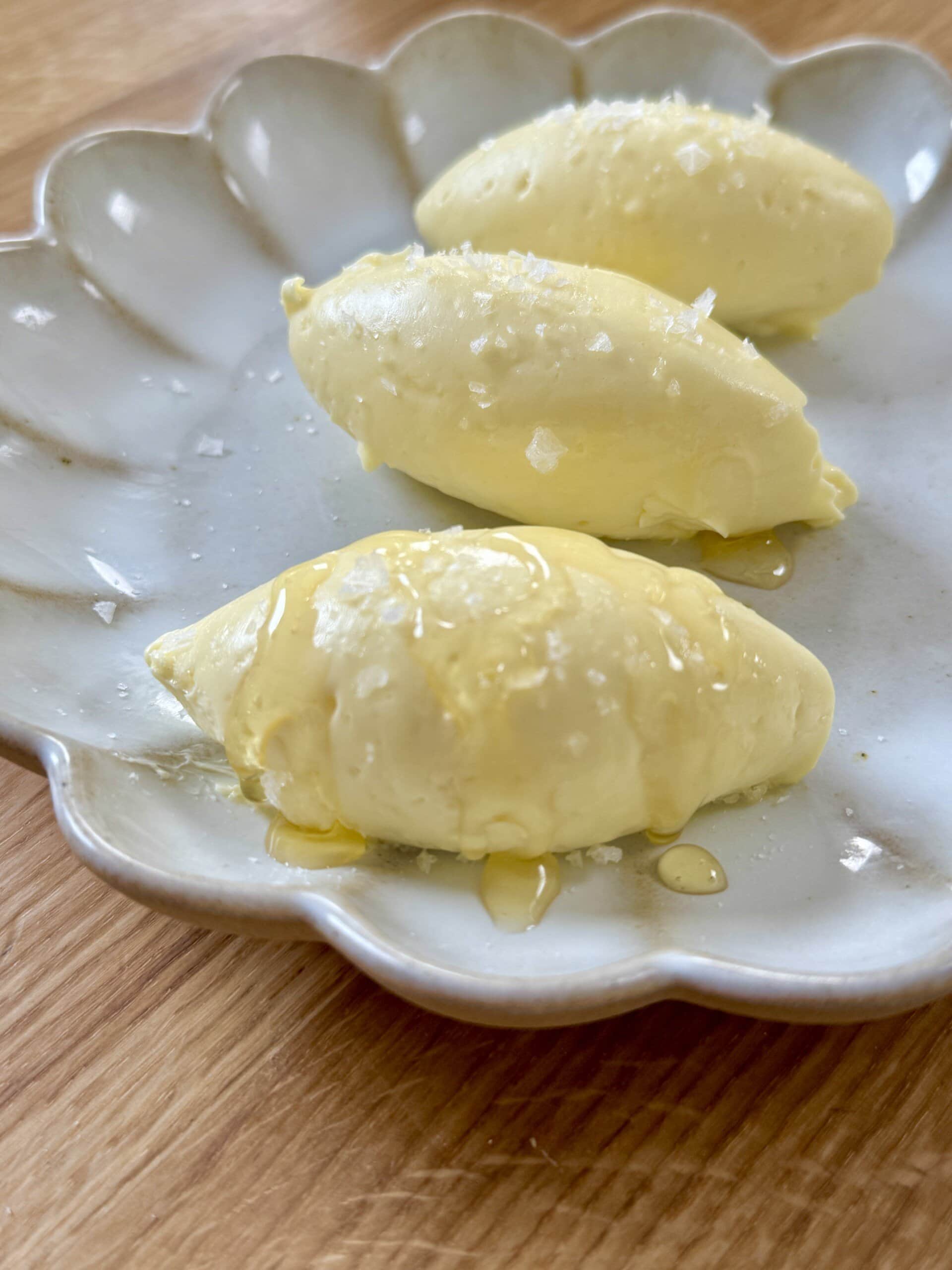 whipped honey butter on plate drizzled with honey.