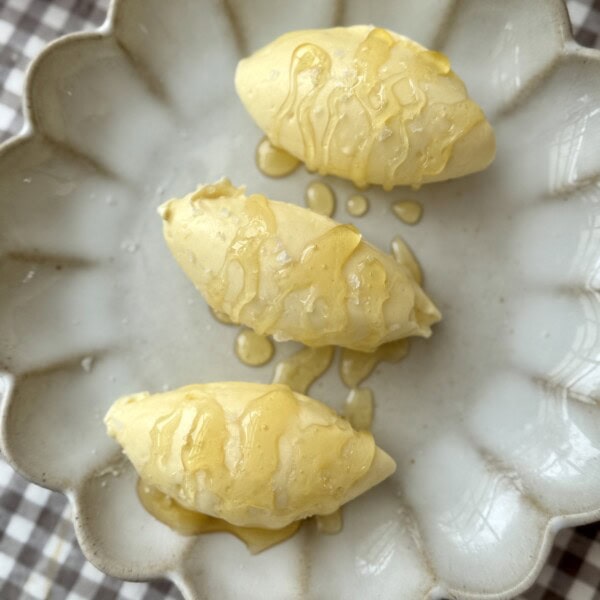 whipped honey butter on plate drizzled with honey.