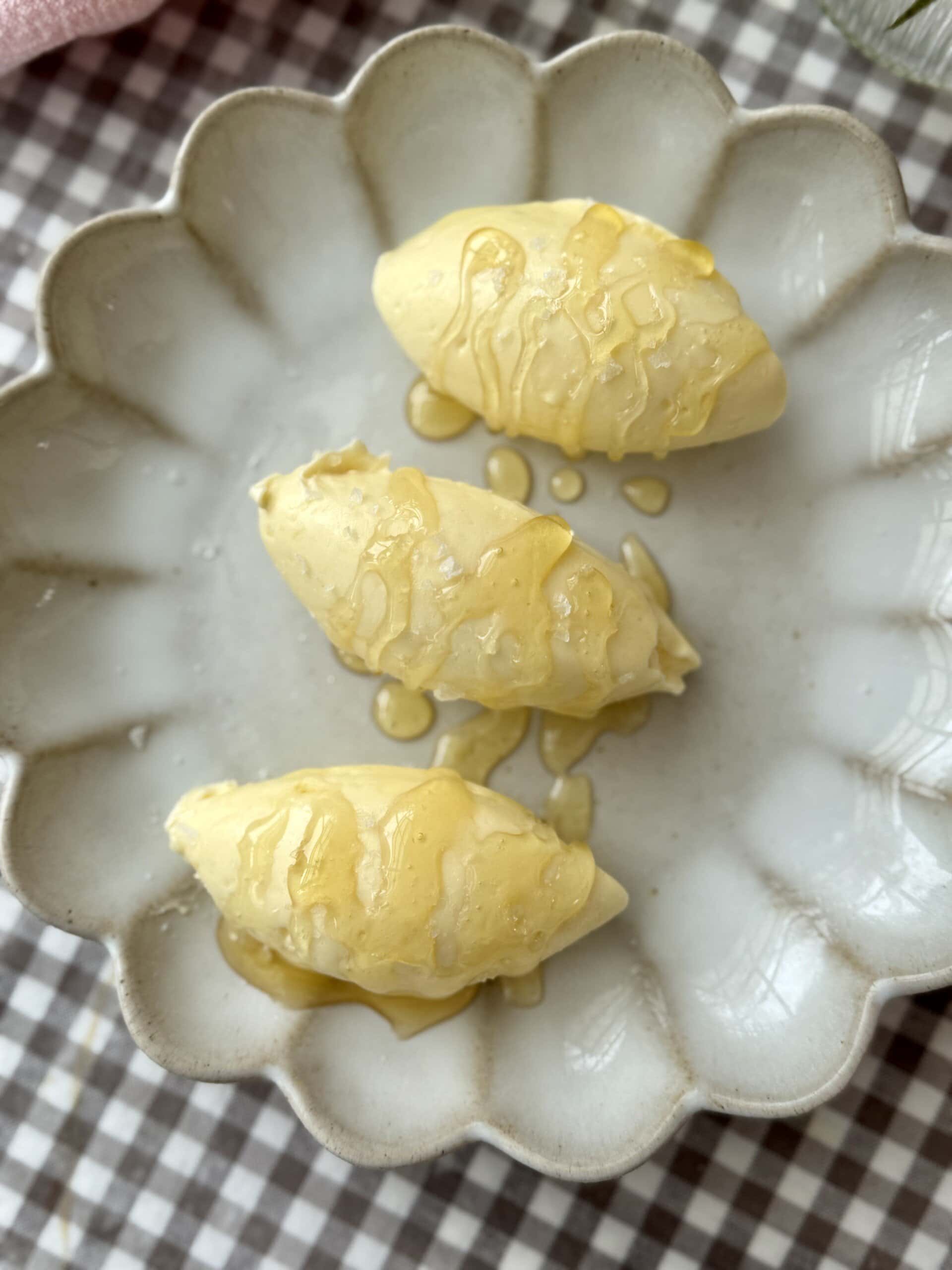 whipped honey butter on plate drizzled with honey.