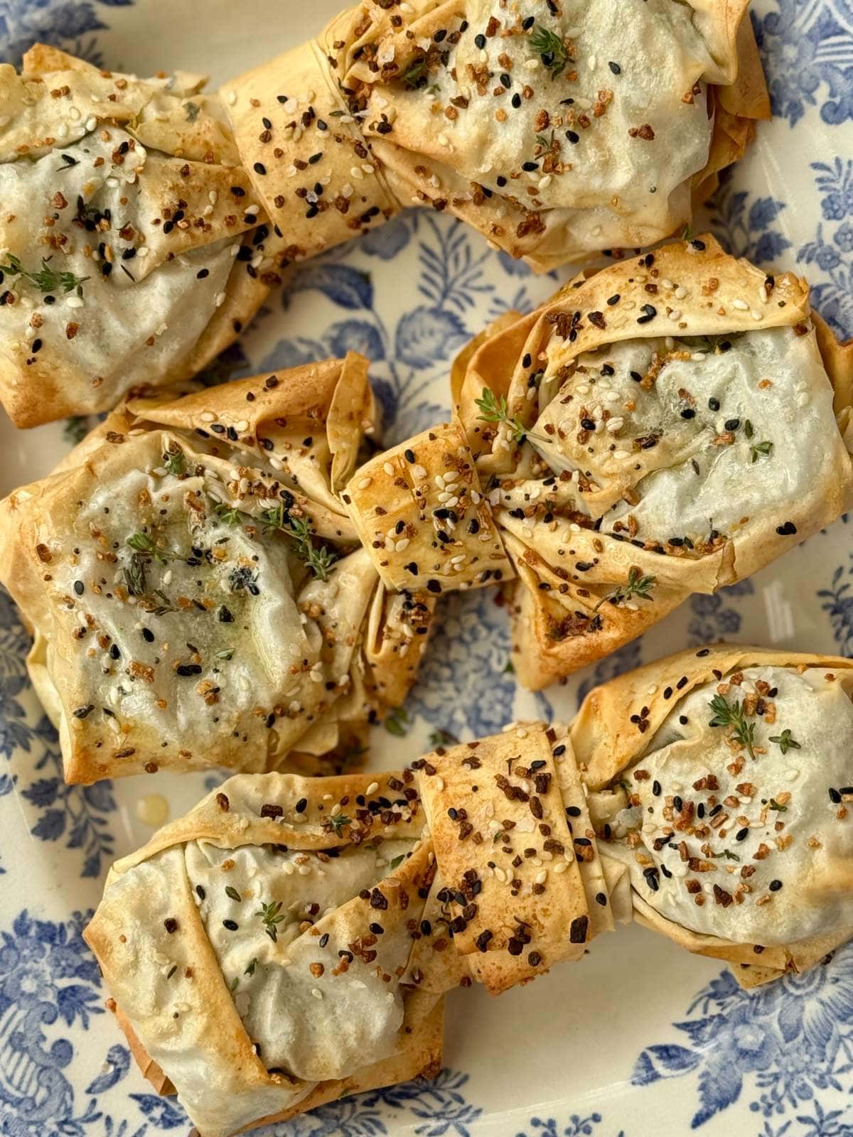spinach feta filos bows on a blue plate.