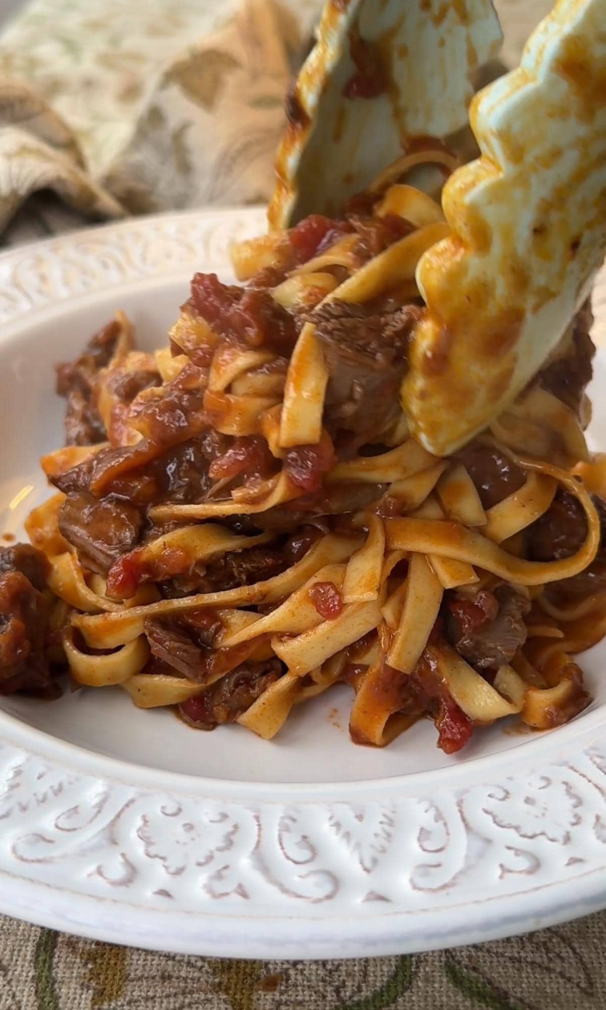 adding beef shin ragu to a bowl.
