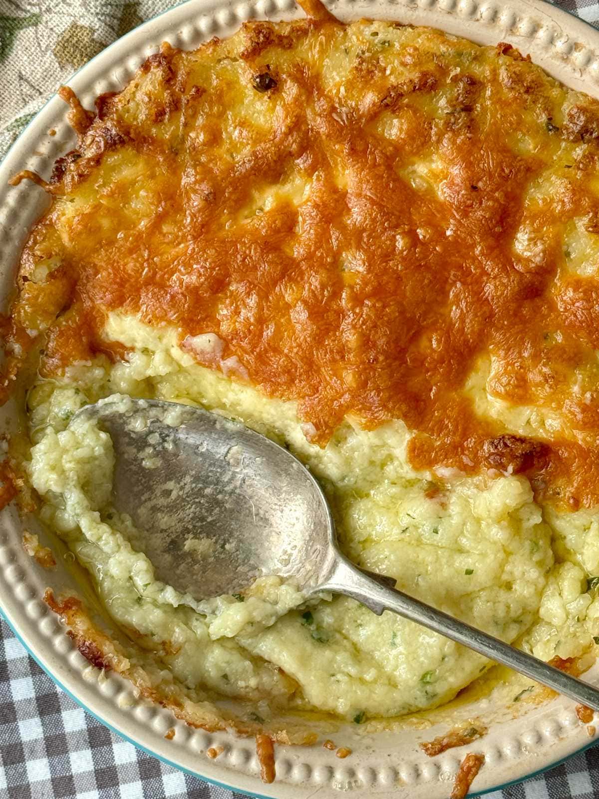 twice baked mashed potatoes in a dish with cheese on top.