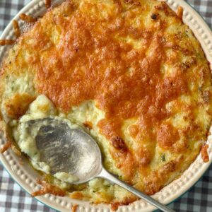 twice baked mashed potatoes in a dish with cheese on top.