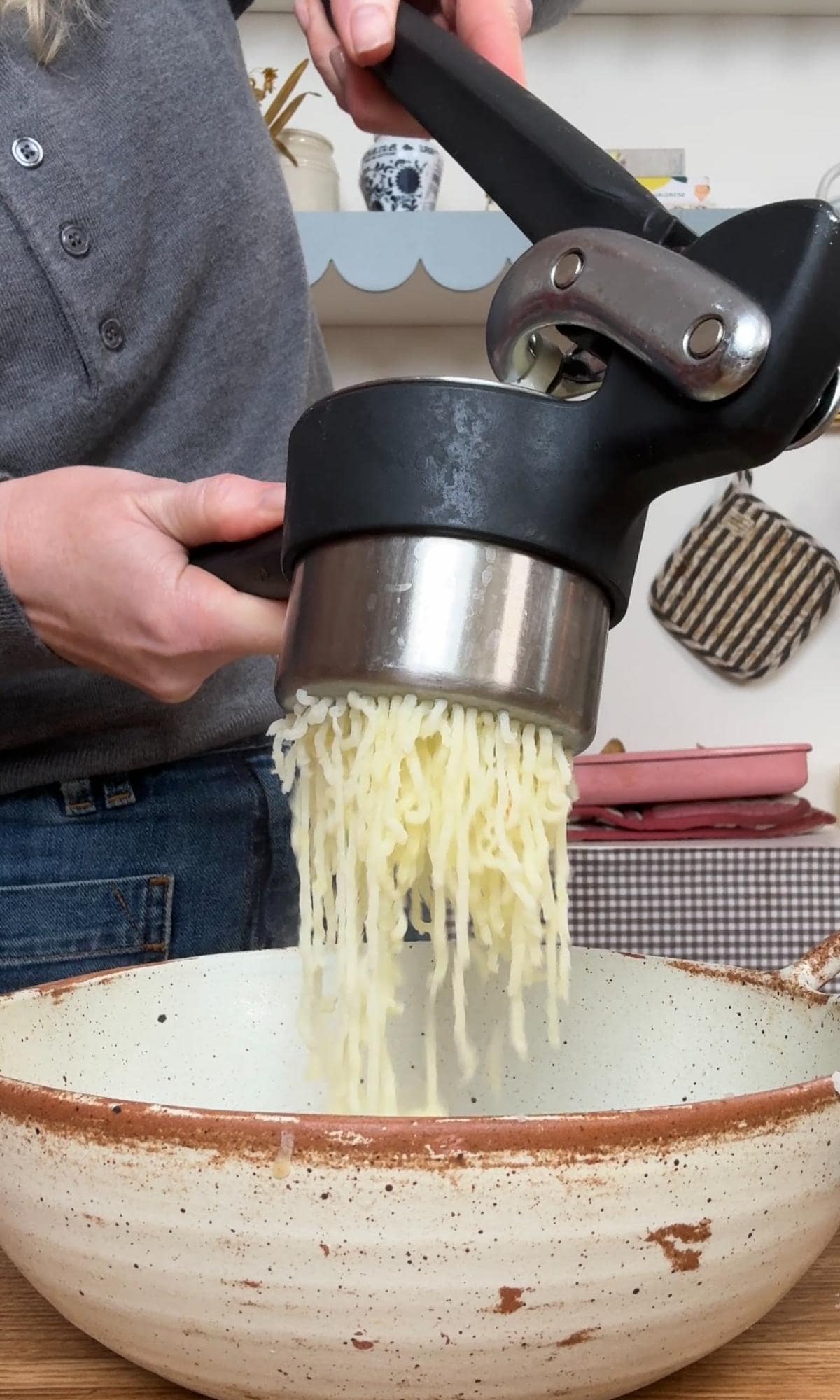 mashing potato into a bowl.
