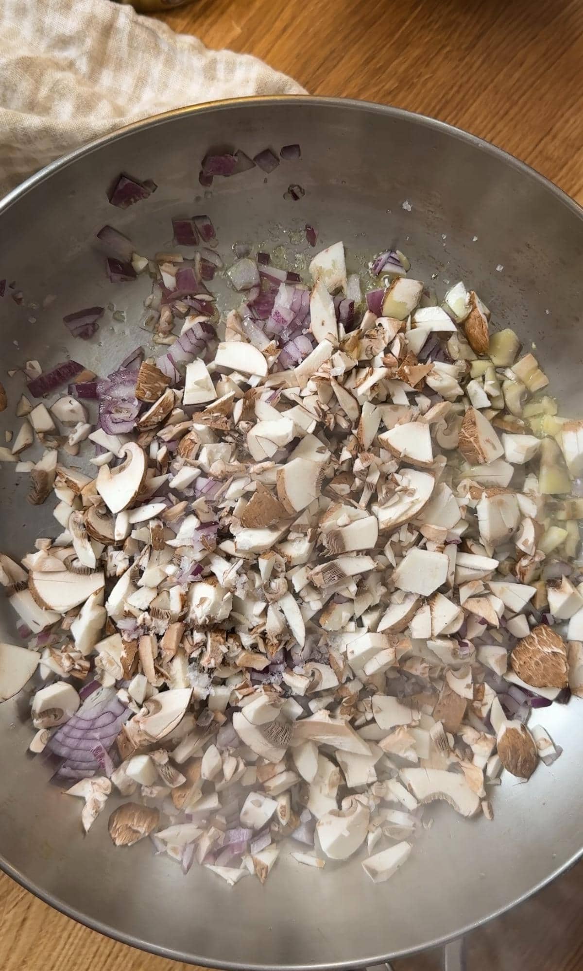 adding mushrooms to a pan.