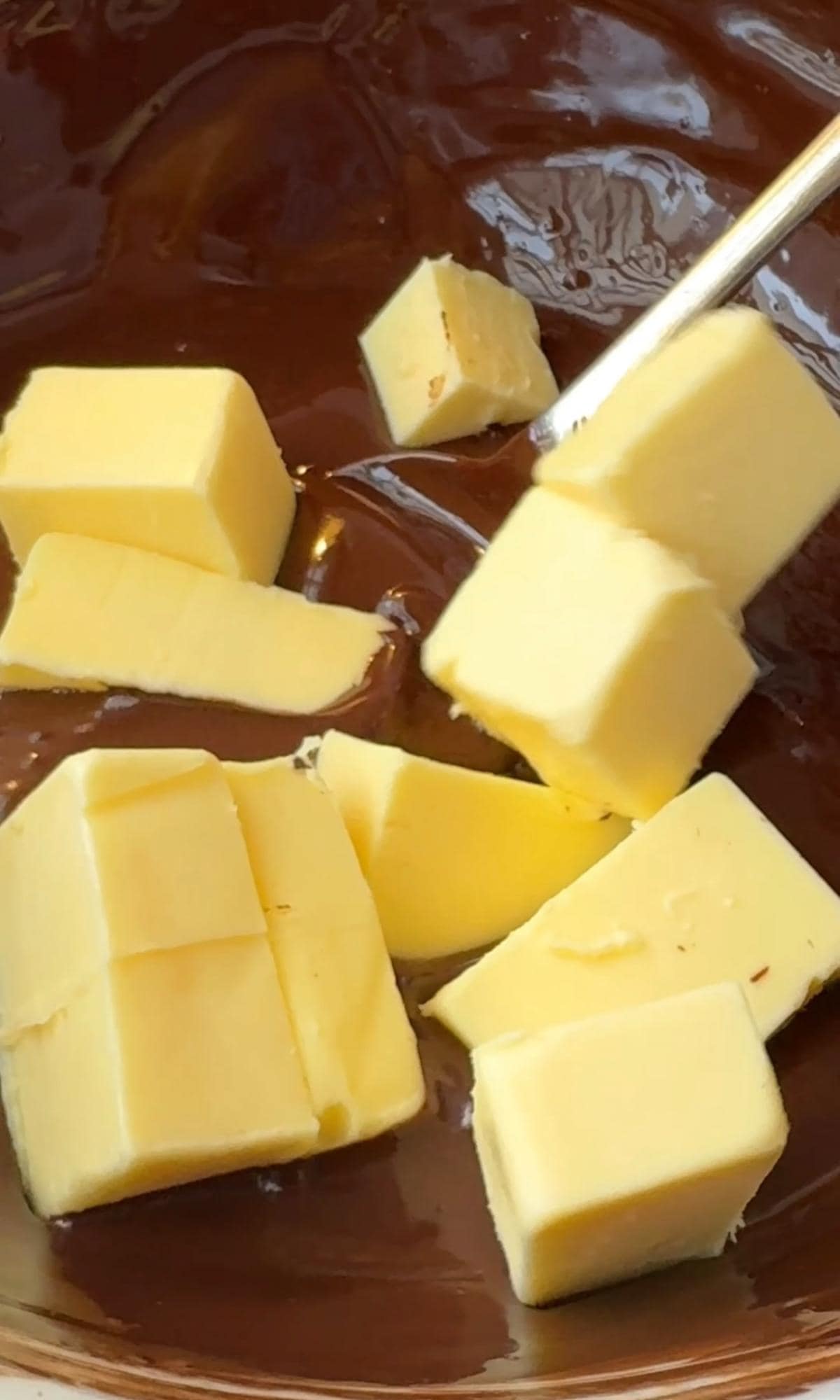 adding butter to melted chocolate.