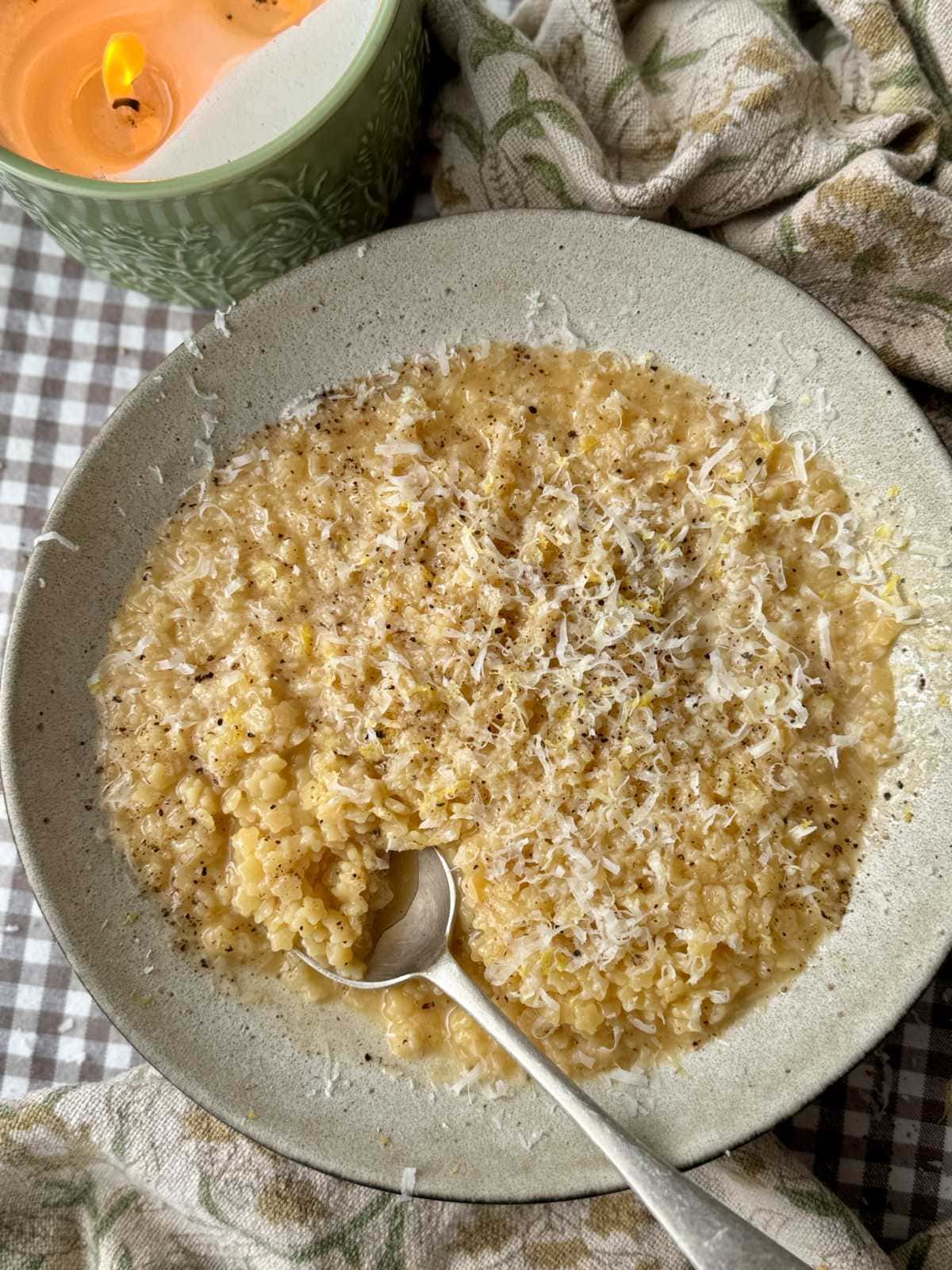 a bowl of creamy pastina with a spoon in the bowl.