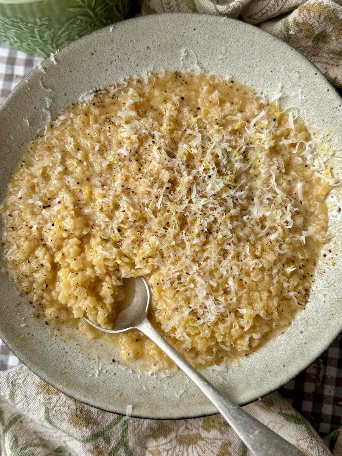 a bowl of creamy pastina with a spoon in the bowl.