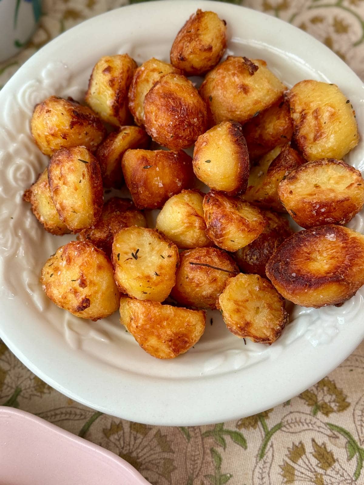 roasted white potatoes with rosemary in a white bowl.