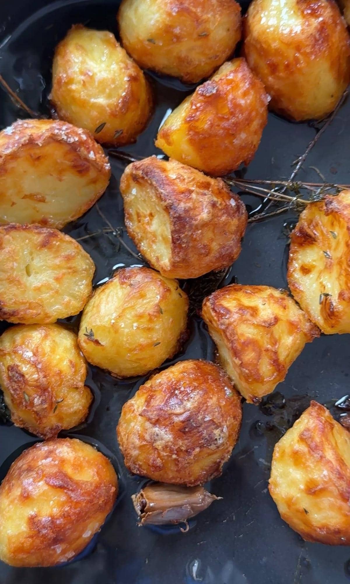 roasted white potatoes with rosemary on a baking tray.