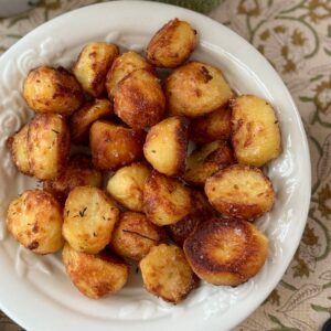 roasted white potatoes with rosemary in a white bowl.