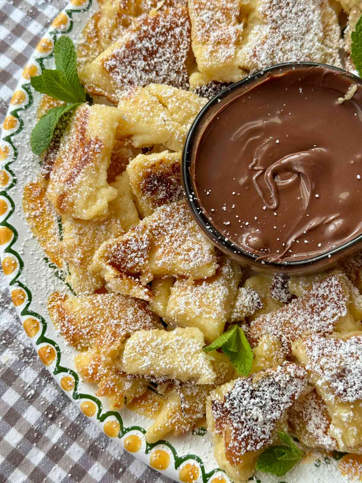 Kaiserschmarrn on a plate with powdered sugar.
