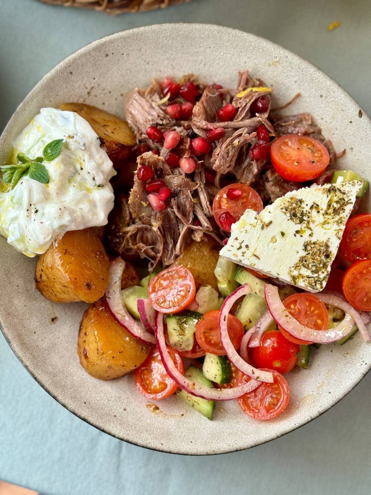 slow cooked lamb with potatoes and greek salad.
