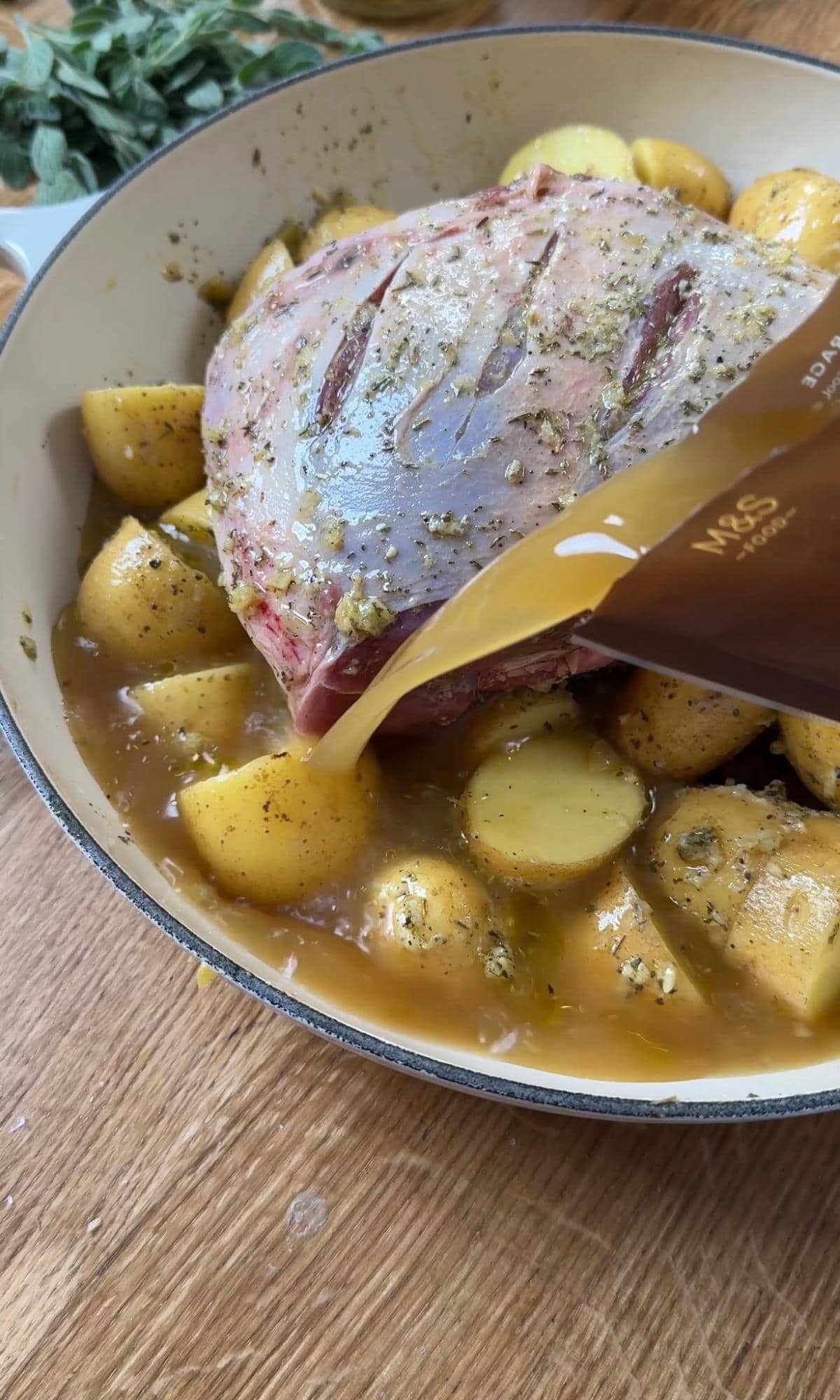 pouring chicken stock over potatoes.
